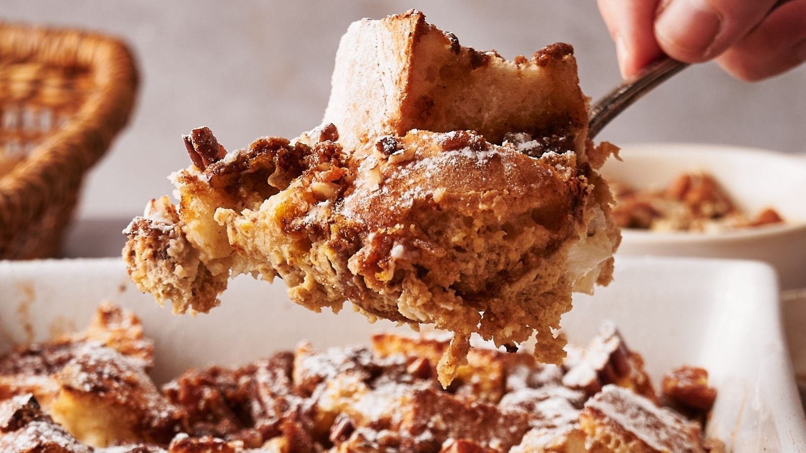 A person taking a portion of French toast casserole.